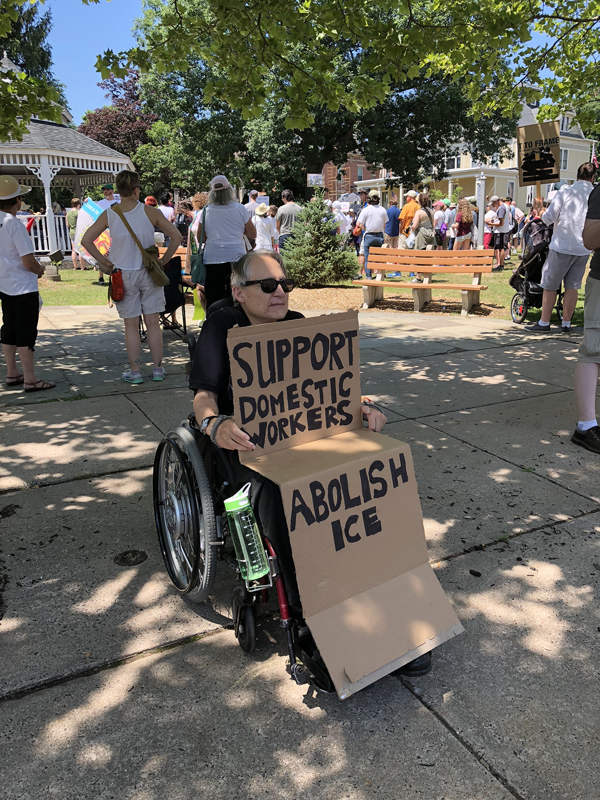 Christina Crosby at protest holding sign that says Support Domestic Workers, Abolish ICE